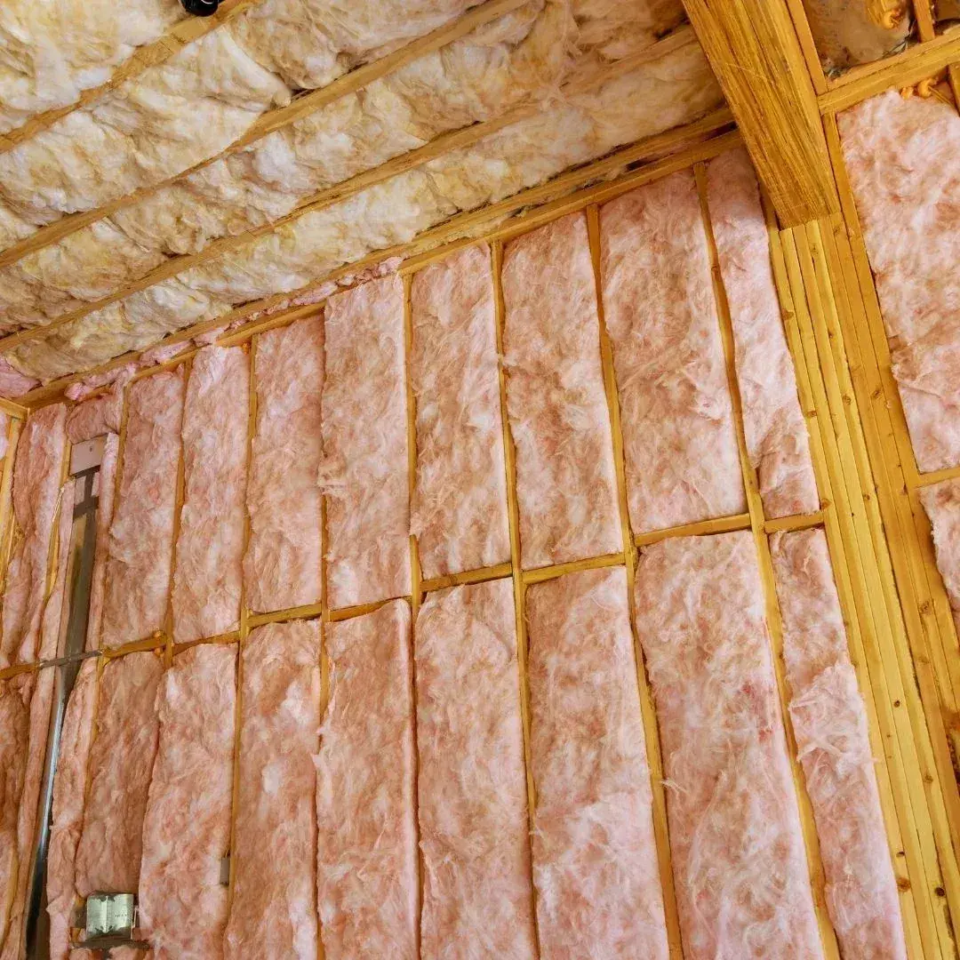 Fiberglass insulation batts installed in the wall and ceiling framing of a Lubbock, TX home