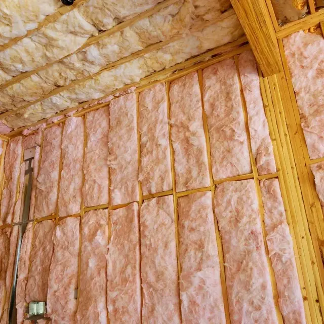 Fiberglass insulation batts installed in the wall and ceiling framing of a Lubbock, TX home